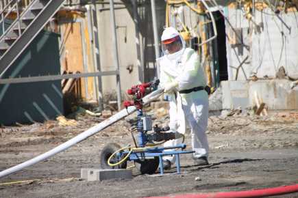 A demolition worker in a white protective suit working at the Hanford site in 2009