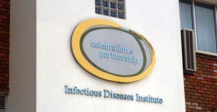 The side of a building with the words “celebration of partnership” and “Infectious Diseases Institute” 