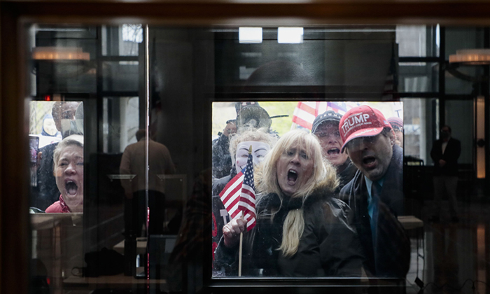 Crowd of anti-social-distancing protesters in Ohio yelling behind closed glass doors