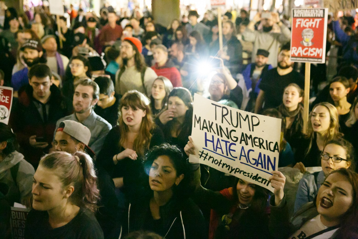 Student holding a "Make America Hate Again" poster at UW protest against Racism