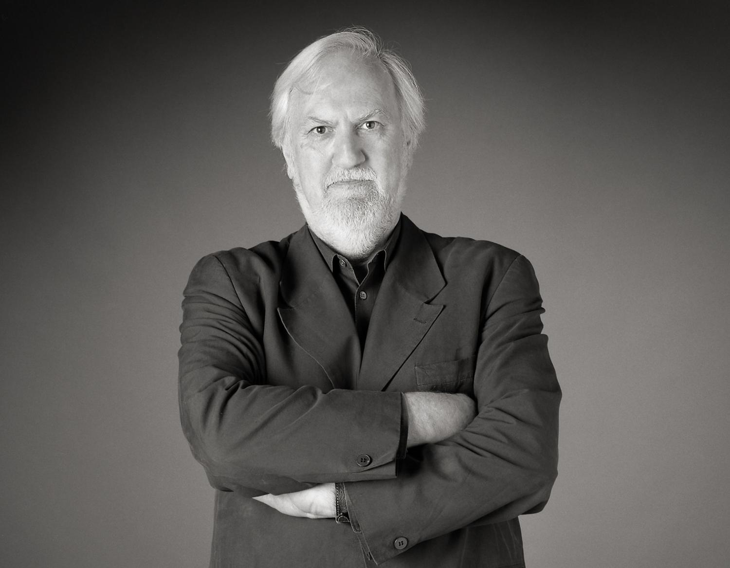 A black and white image of Anthony Vidler facing the camera with his arms crossed.