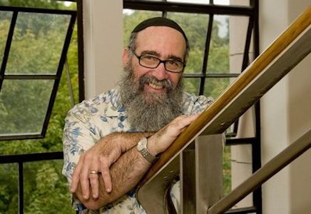 Martin Jaffee leans on a banister with his arms crossed.