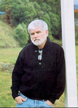 Mike Davis wears a dark shirt and leans against a pole.