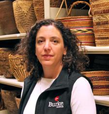 Katie Bunn-Marcuse stands in front of shelves holding baskets.