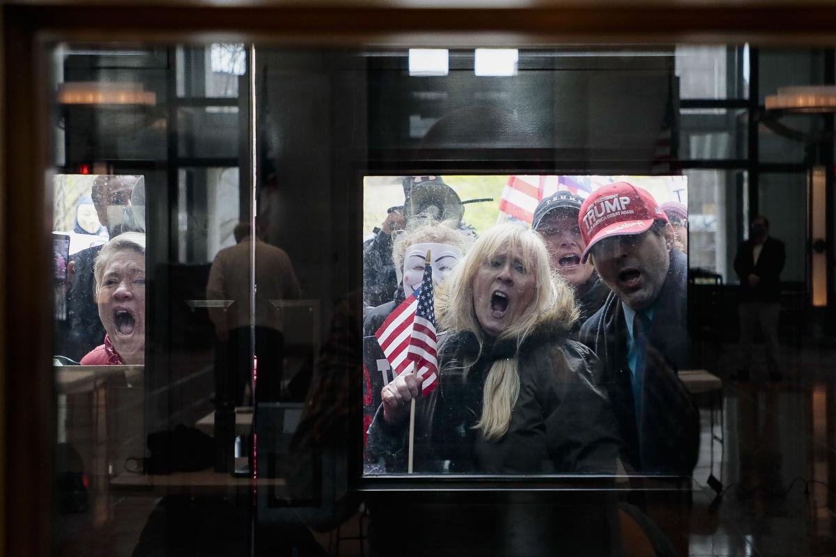 Crowd of anti-social-distancing protesters in Ohio yelling behind closed glass doors