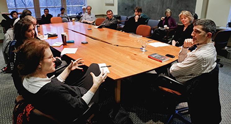UW Humanities faculty members hold a discussion around a large table.