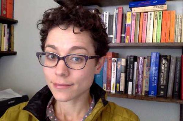 Annie Dwyer stands in front of two shelves of books.