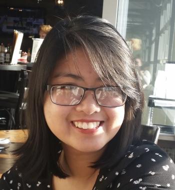 A portrait of Anna Nguyen wearing glasses.