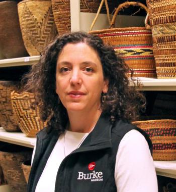 Katie Bunn-Marcuse stands in front of shelves holding baskets.