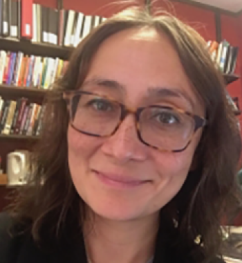 Portrait of Candice Rai sitting in front of a bookcase.