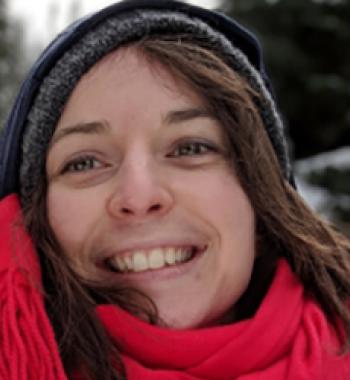 A close up portrait of Céline Maillard wearing a hat and red scarf.