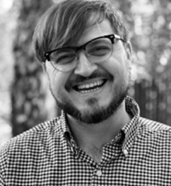 A black and white image of Darren Byler wearing glasses.