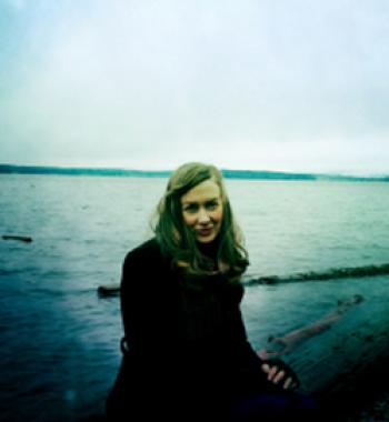 Erin Gilbert stands in front of a body of water.