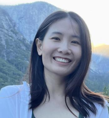 Jingsi Shen stands outside with mountains in the background.