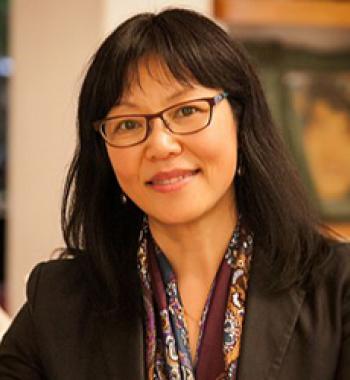 Portrait of Madeleine Dong wearing glasses, a scarf, and a dark jacket.