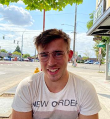 Photo of Alec Fisher in front of a palm tree.