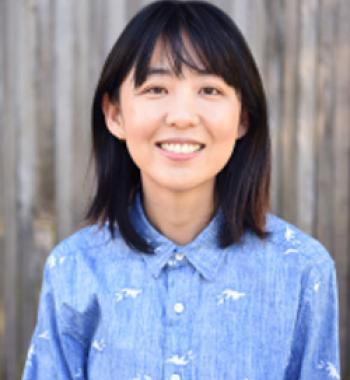 Portrait of Ellen Y. Chang standing in front of a blurred background and wearing a blue collared shirt.