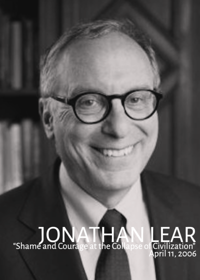 A black and white image of Jonathan Lear looking into the camera while wearing a suit and tie and glasses.