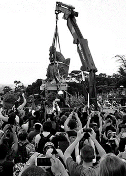 The bronze statue of imperialist Cecil Rhodes is removed in Cape Town on 9 April 2015 as protesters film the event