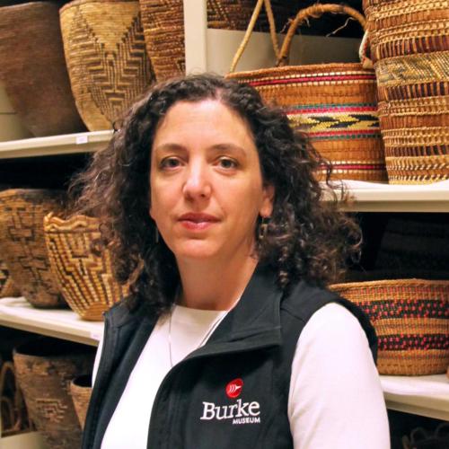 Katie Bunn-Marcuse stands in front of shelves holding baskets.