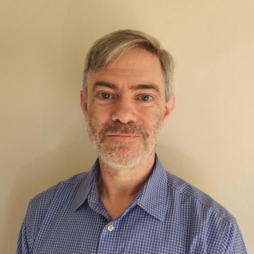 Eric Johnson smiling wearing a blue shirt