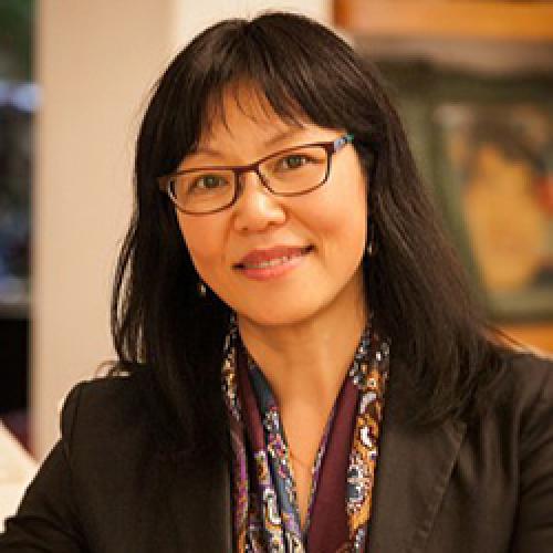 Portrait of Madeleine Dong wearing glasses, a scarf, and a dark jacket.
