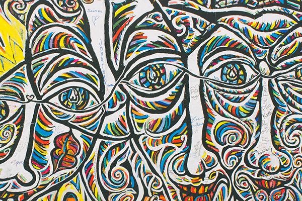 Abstract painting of multicolored faces.