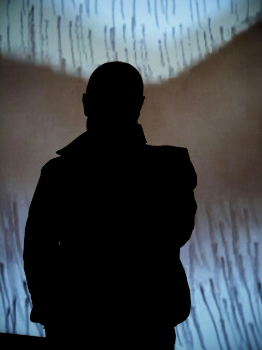 Silhouette of person in front of screen