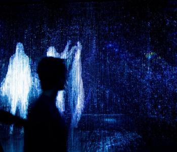 Abstract image of white ghost-like figures framing the outline of a person on a dark background.