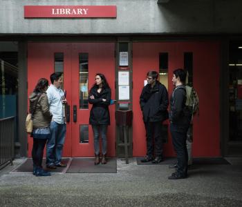 Students stand outside a library at a community college.