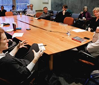 UW Humanities faculty members hold a discussion around a large table.