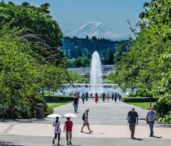 The UW campus in the summer, with the Drumheller Fountain and Mount Rainier visible in the distance