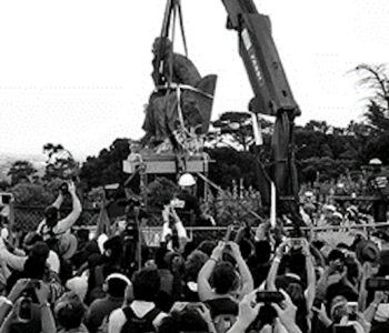 The bronze statue of imperialist Cecil Rhodes is removed in Cape Town on 9 April 2015 as protesters film the event