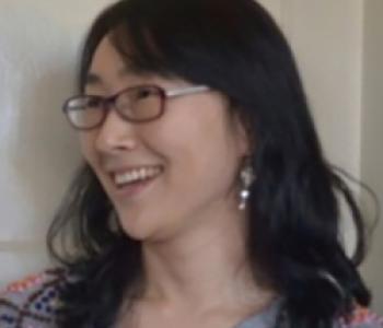 Heekyoung Cho looks to the left while wearing glasses.