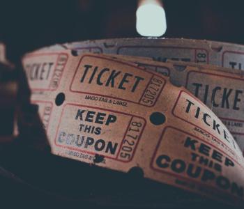A spool of movie tickets on a black background.