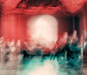 Blurred images of dancers on a stage with red curtains behind them.