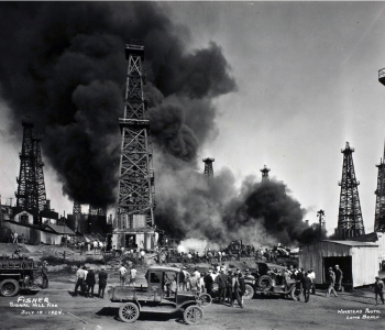  Crowds watching oil fields accident, smoke coming out of oil rigs. Circa 1920