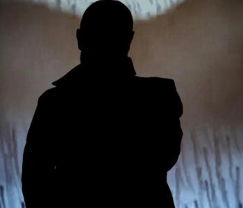 Silhouette of person in front of screen